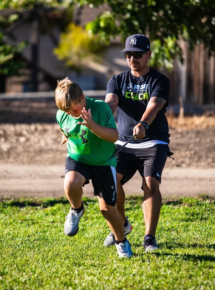 Coach Morales running a resistance band sprint drill