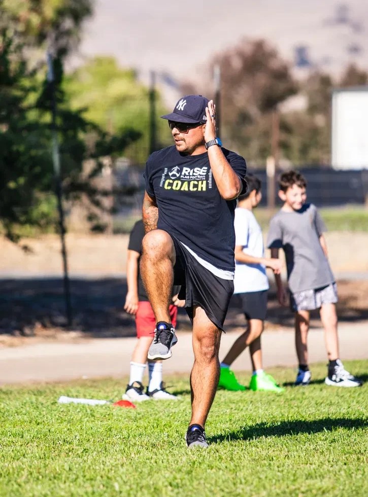 Coach Morales demonstrating high knees to the group